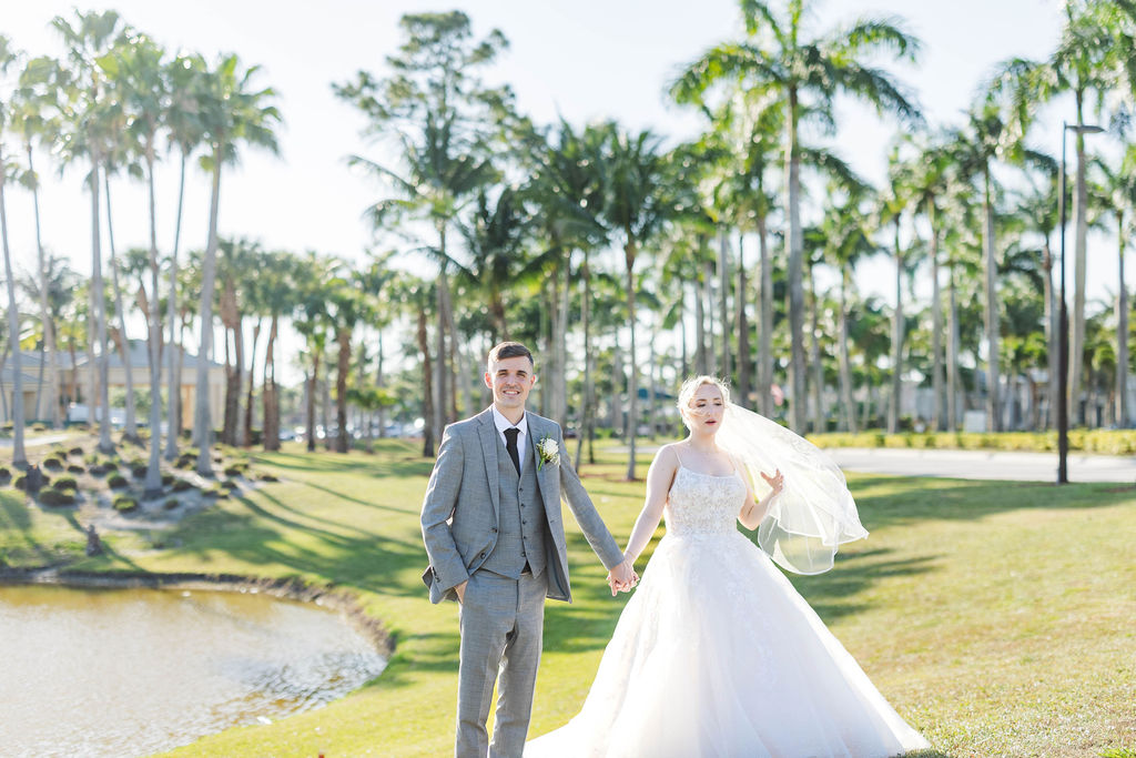 Wedding venue outdoor ceremony site by the water with bride and groom wearing luxury wedding dress and designer wedding suit