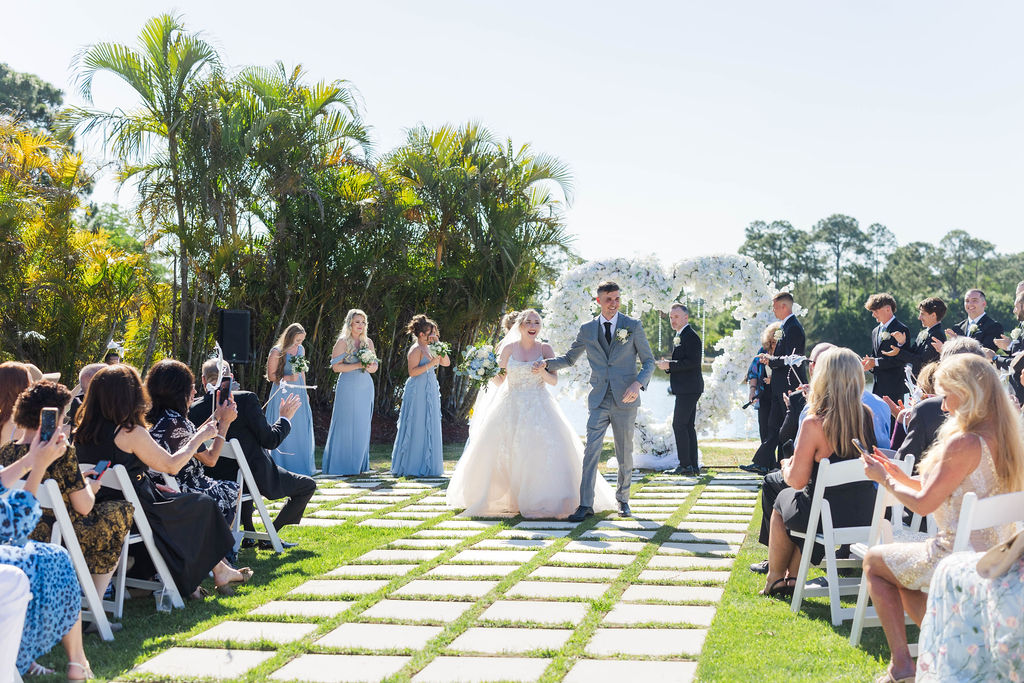 Palm Beach outdoor wedding ceremony with the bride wearing a luxury wedding dress and the groom wearing a designer wedding suit