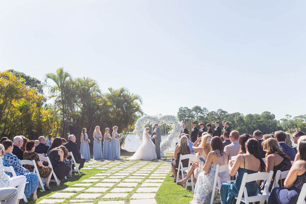 Bride and groom exchange vows at an outdoor waterfront wedding ceremony. Planning the Ultimate Engagement Party and an All-Inclusive Wedding Venue.